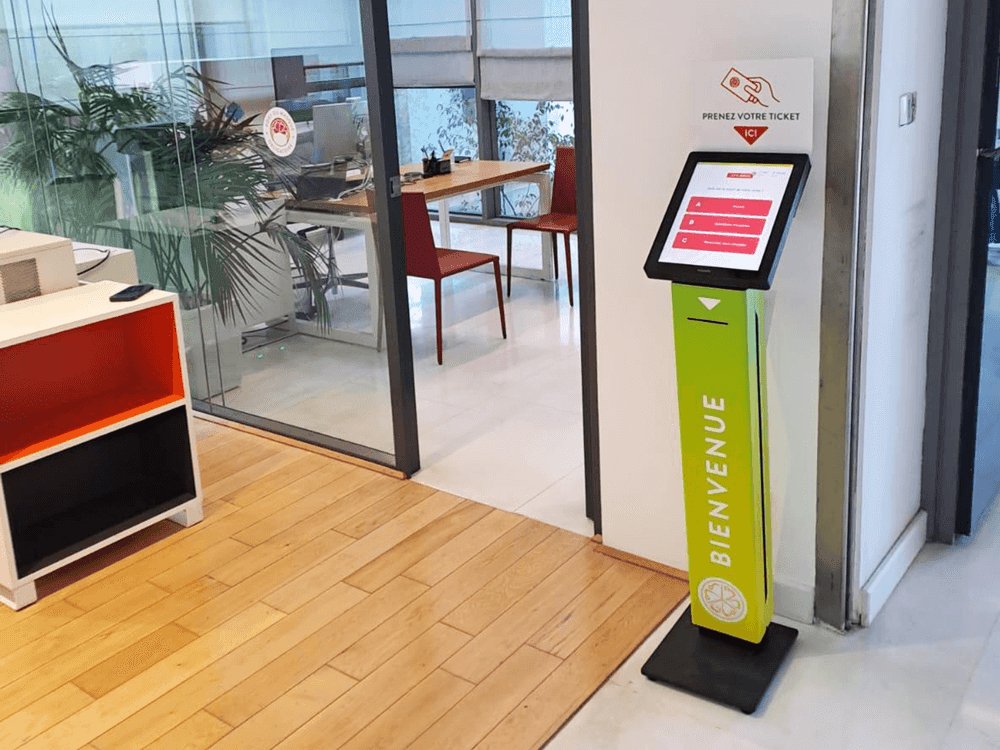 Close-up of the Moviik TIKK 15 ticket dispenser at CFG Bank, showing its compact design and touchscreen interface. Close-up of the Moviik TIKK 15 ticket dispenser at CFG Bank, showing its compact design and touchscreen interface.