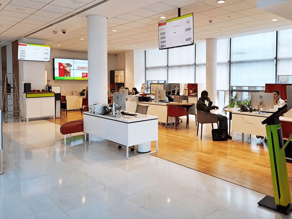 View of CFG Bank’s Casablanca branch showing customer service desks and Moviik’s digital queue display in operation.