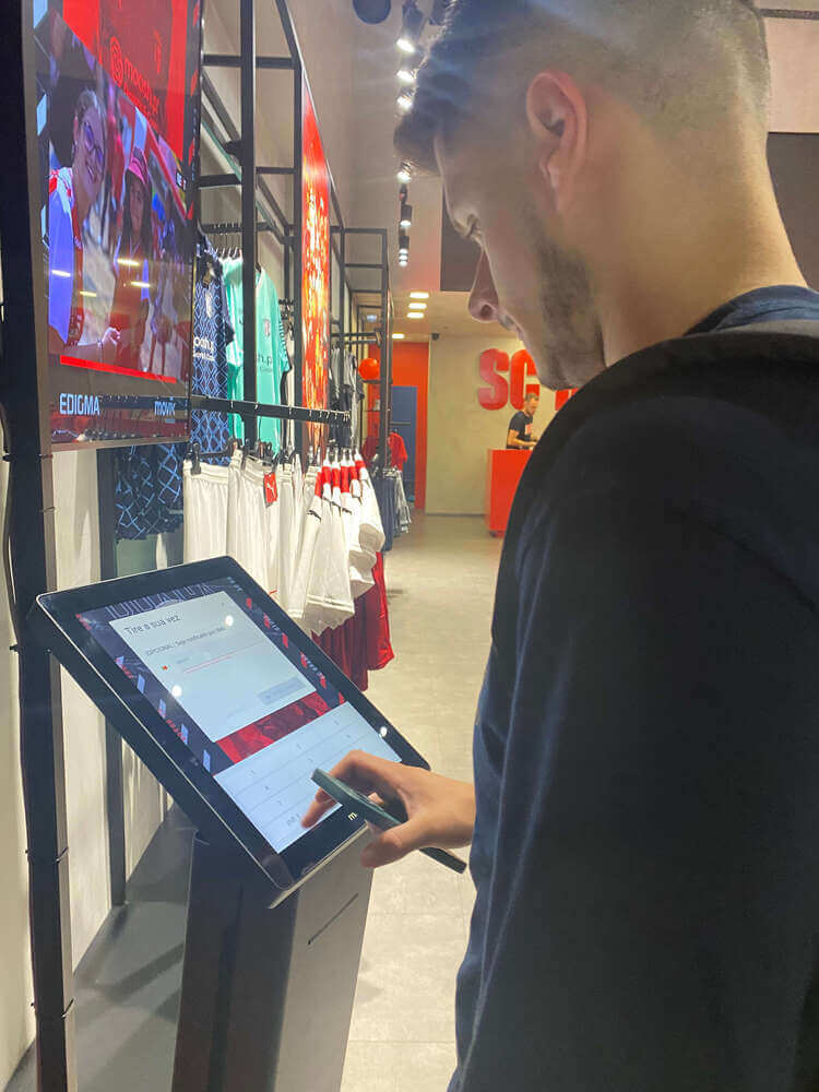 A fan using the kiosk to take a paper or SMS ticket at SC Braga official store. A fan using the kiosk to take a paper or SMS ticket at SC Braga official store.