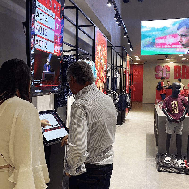 Queue system implementation showing QR codes, kiosks, and customers joining digitally during rollout.