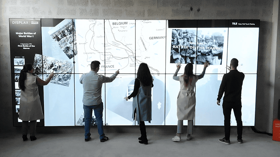 Visitors interacting simultaneously with the DISPLAX TILE Pro video wall in a public space. Visitors interacting simultaneously with the DISPLAX TILE Pro video wall in a public space.