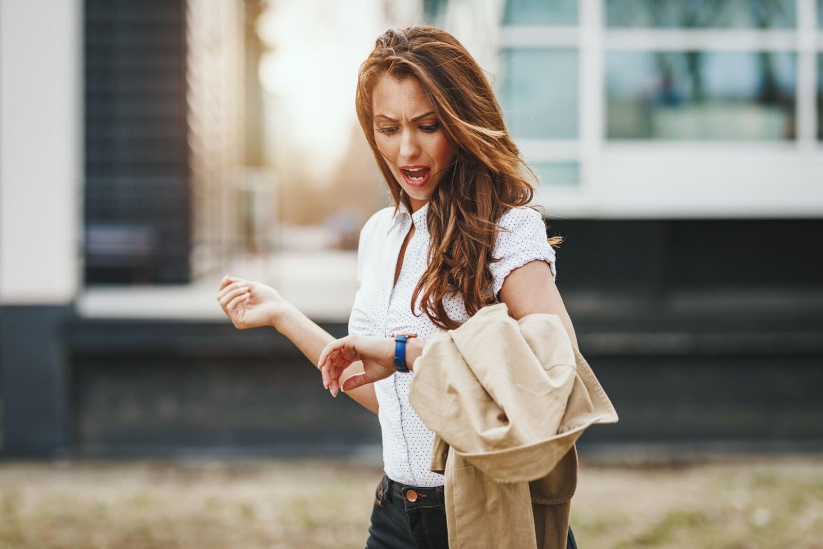 Frustrated customer looking at their watch while standing in a retail store queue Frustrated customer looking at their watch while standing in a retail store queue