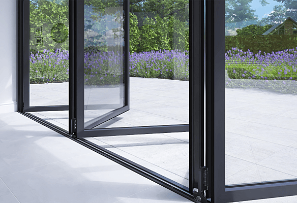 Slim profile Korniche aluminium bi-fold doors opening onto a garden patio